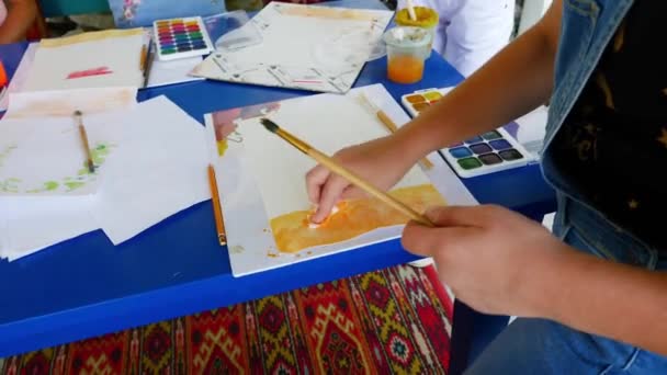 Menina aprende a pintar com tintas aquarela . — Vídeo de Stock