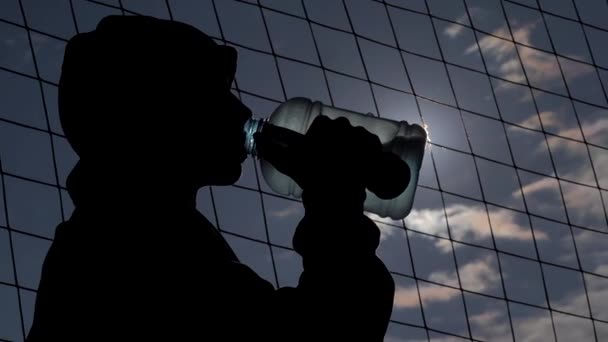 Юный спортсмен пьет воду из бутылки после тренировки — стоковое видео