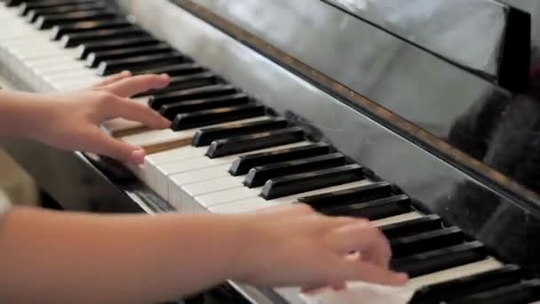 A rapariga está a tocar piano. Mãos bonitas. tecla piano — Vídeo de Stock