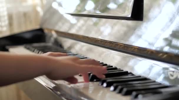 A rapariga está a tocar piano. Mãos bonitas. tecla piano — Vídeo de Stock