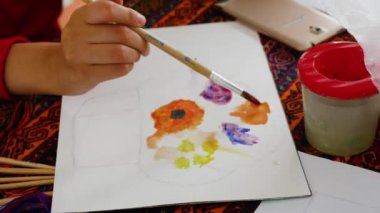 Küçük kız suluboya resimlerle resim yapmayı öğreniyor..