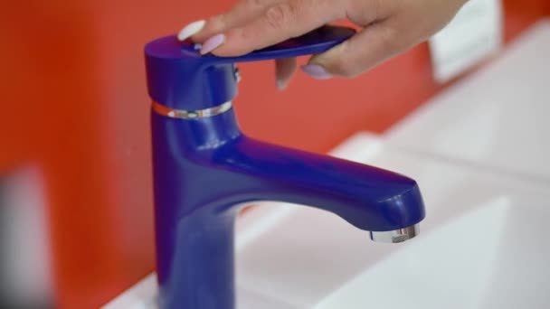 A woman chooses a water tap in the bathroom at the plumbing store — Stock Video