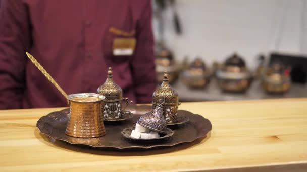 L'homme enlève un plateau avec des tasses orientales et cezve avec du café — Video