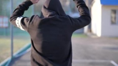 Kapüşonlu genç bir adam antrenmandan önce ısınıyor. fitness