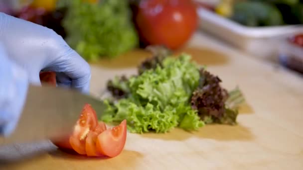 I köket i restaurangen mannen skär tomat för sallad. Trädgårdssallat — Stockvideo