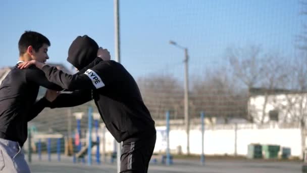 Утром на спортивной площадке юные спортсмены демонстрируют борцовские техники — стоковое видео
