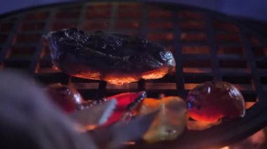 Yakın çekim. Şef sebzeleri ve eti ızgarada kızartıyor. yavaş çekim