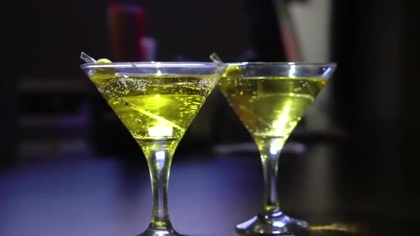 Close-up. glasses with martini or gin on the bar. Martini with olive. — Stock Video