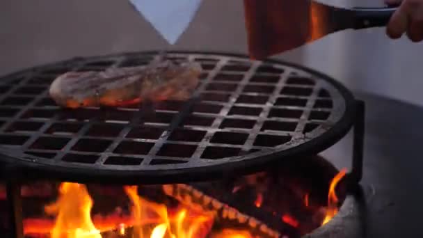 スローモーション。炭火焼のステーキ揚げ。シェフは肉を回します。閉鎖 — ストック動画