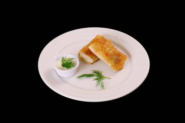 Beyaz soslu ve dereotlu beyaz tabağa doldurulmuş krep. Siyah arka plan. Görünüm