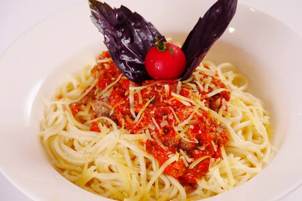 Kıyma, domates sosu ve peynirli spagetti. Fesleğen Beyaz arkaplan
