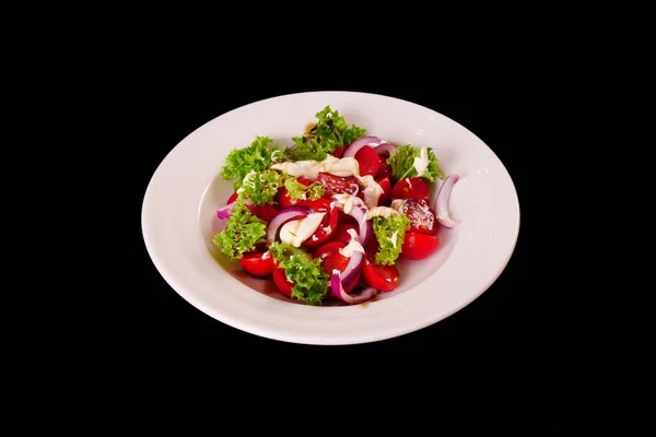 Tomato salad with onions and sour cream. Lettuce leaves. Black background — Stock Photo, Image