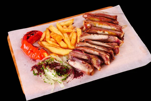 Izgarada kaburga, biber, domates, patates kızartması, tahtadan soğan