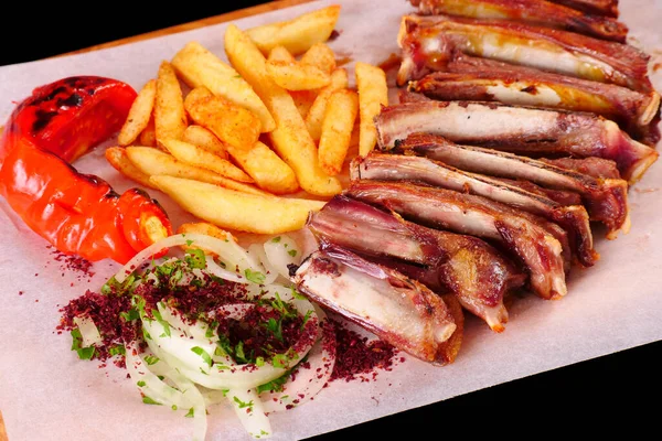 Izgarada kaburga, biber, domates, patates kızartması, tahtadan soğan