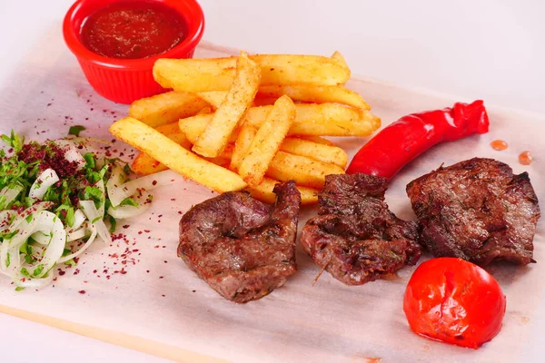 Kebap, biber, domates, patates kızartması, tahtadan yapılmış soğan. Beyaz arkaplan