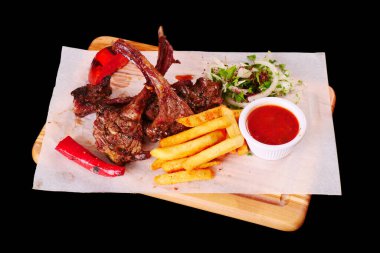 Izgara kuzu pirzolası, biber, domates, patates kızartması, ahşap tahtada ketçap soğan