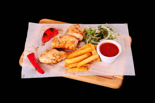 Grilled chicken fillet, chili, tomato French fries ketchup onion on wooden Board