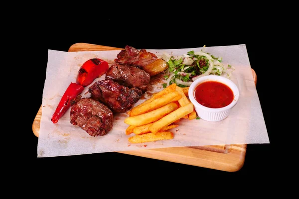 Kebap, biber, domates, patates kızartması, tahtadan yapılmış soğan. Siyah arkaplan