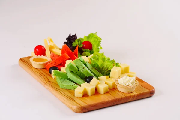 Assiette au fromage, pesto rouge et vert, tomates à la laitue sur le plateau en bois — Photo