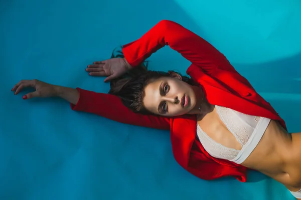 Schöne Frau Liegt Spitzenunterwäsche Auf Blauem Hintergrund Roter Jacke Modell — Stockfoto