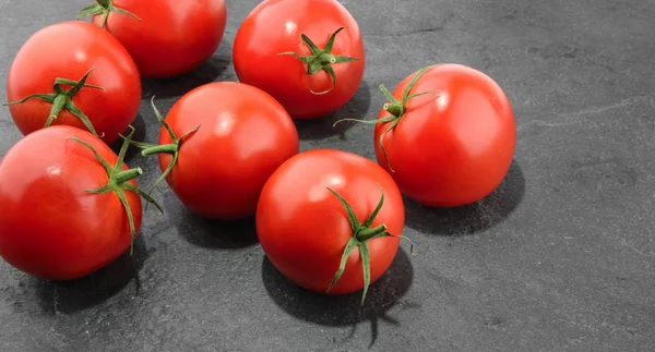 Pomidory na ciemnym tle kamień, widok z góry — Zdjęcie stockowe