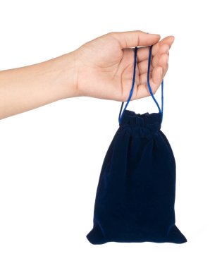 El ele tutuşan mavi kadife çanta beyaz arkaplanda izole edilmiş.