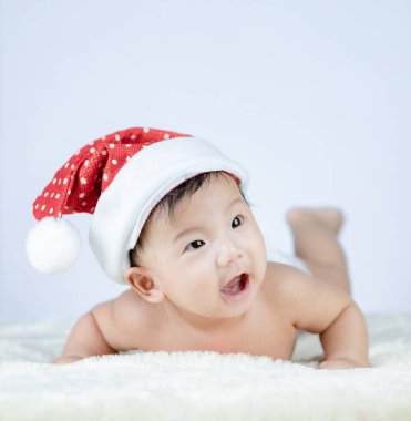 Noel Baba şapkası takan şirin bir bebeğin Noel portresi..