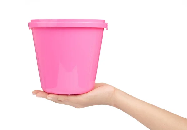 Hand vasthouden Roze plastic emmer voor water geïsoleerd op witte bac — Stockfoto