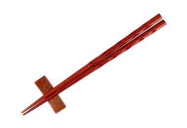 pair of wood chopsticks with wood holder isolated on a white bac