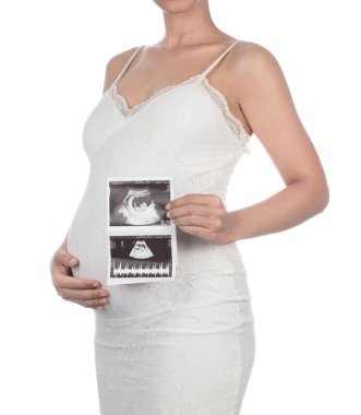 Pregnant woman holding ultrasound scan on her belly isolated on 
