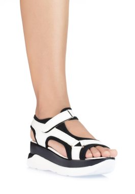 Beyaz rahat sandalet giyen kadın bacağı beyaz ba 'da izole edilmiş.