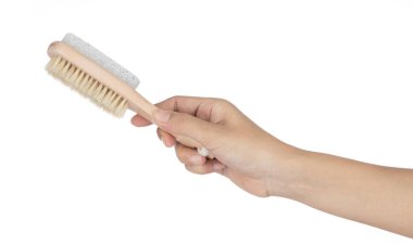 Hand holding brush with stone scrub foot hygiene tool isolated o