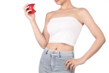 young woman wearing white strapless dress and jeans holding red 