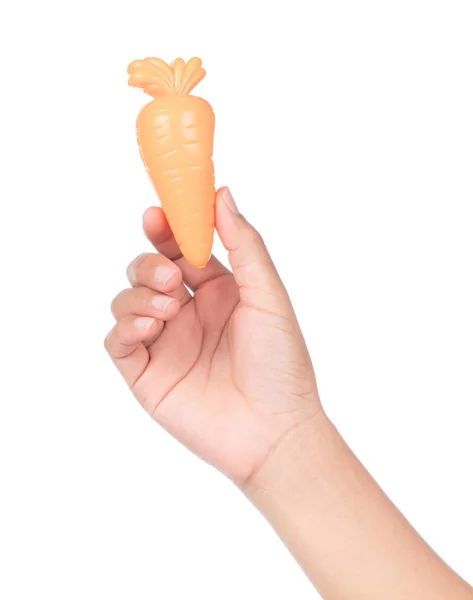Hand holding plastic toy carrot  isolated on white background — Stock Photo, Image