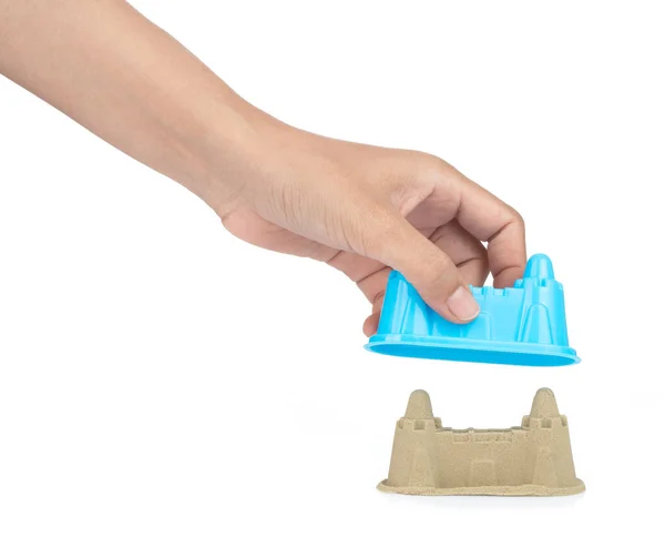Mão segurando plástico Castelo de brinquedos de praia isolados na parte traseira branca — Fotografia de Stock