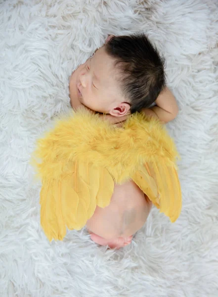 Adorável bebê recém-nascido que coloca em um tapete de pele com asas de anjo — Fotografia de Stock