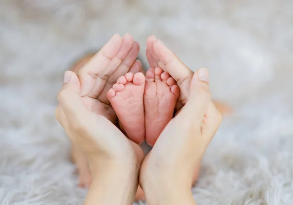 Mom holding in the hands feet of newborn baby. — Stock Photo, Image