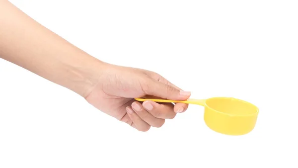 Hand holding yellow plastic scoop isolated on white background — Stok fotoğraf