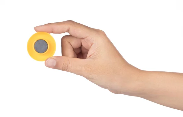 Hand holding Yellow Round Plastic Magnet isolated on white backg — ストック写真