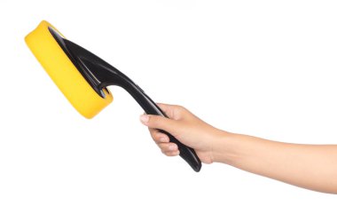 hand holding yellow sponge  with black plastic handle isolated o