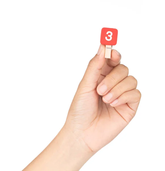 Hand holding clip wooden peg with numbers 3 isolated on a white — ストック写真