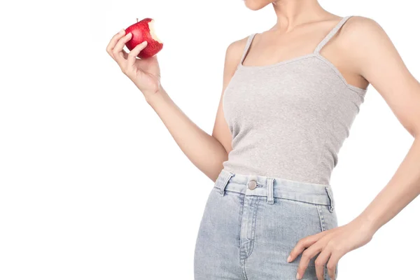 Woman in grey tank top and jeans eating one red apple isolated o — Stock Photo, Image