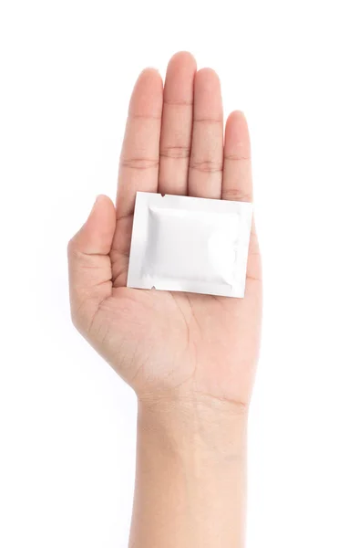 Hand holding wet wipe tablet cleaning in packet isolated on whit — Stok fotoğraf