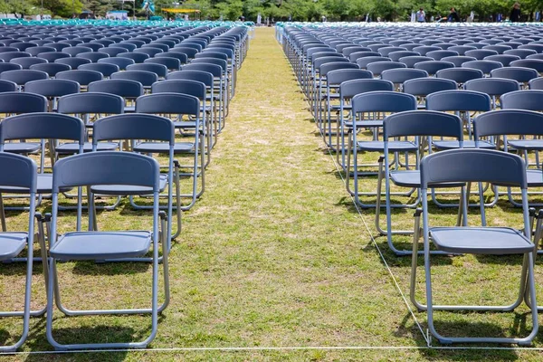 Rows of grey chairs on lawn ceremony in summer time