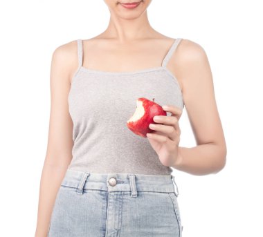 woman in grey tank top and jeans eating one red apple isolated o