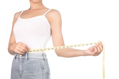 Young woman with a perfect body measures her waist with a measur