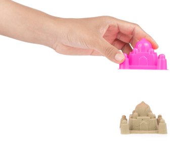 Hand holding plastic Castle of beach toys isolated on white back clipart