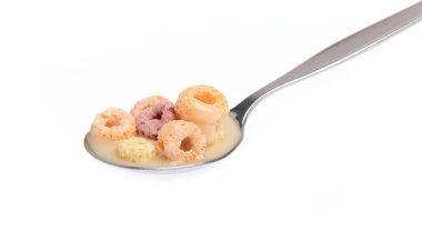 close up of colorful cereal and milk with spoon isolated on white background