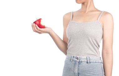 woman in grey tank top and jeans eating one red apple isolated o