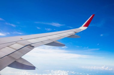 Mavi gökyüzünde uçağın kanadı Pencereden manzaralı